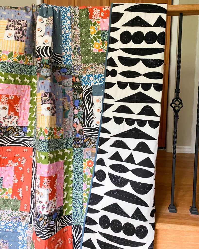 Log cabin quilt made from Cloud9 Fabrics, with Imprint 108 wide backing fabric.