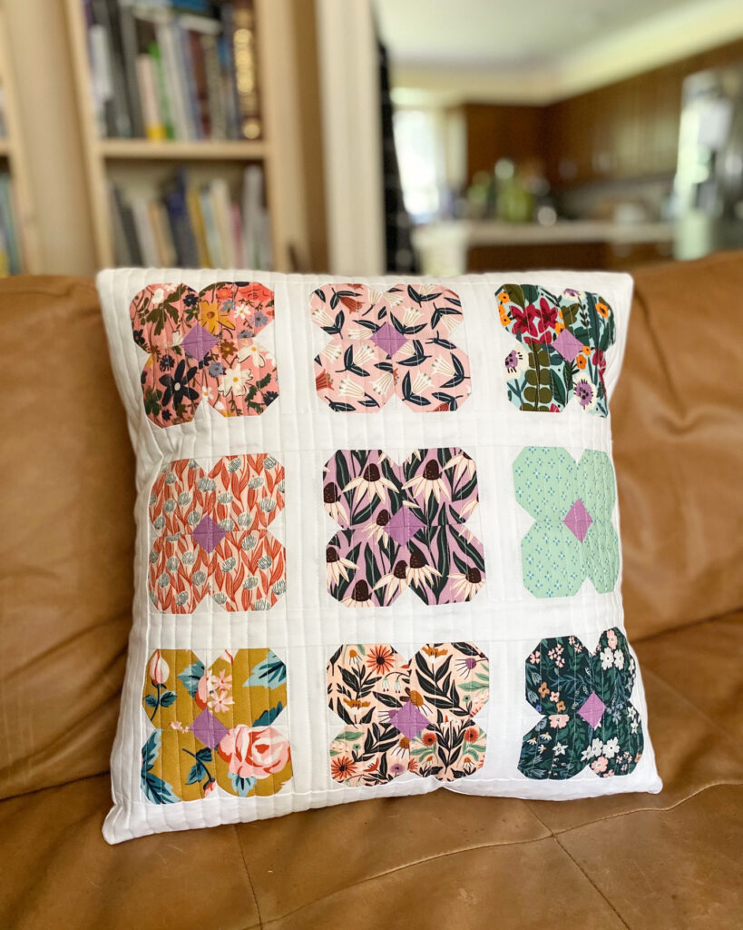 Finished Blossom Pillow Pattern in floral scraps with white background on a couch