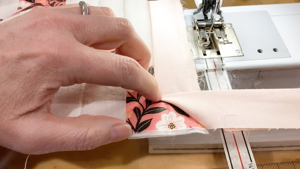 Folding quilt binding up at a 45-degree angle at the corner.