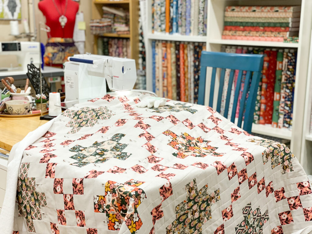 Quilt in the process of being quilted on a domestic sewing machine.