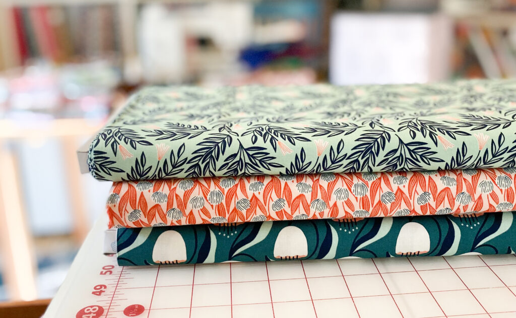 Cutting table with bolts of fabric in the Tangled Threads by Jen studio.